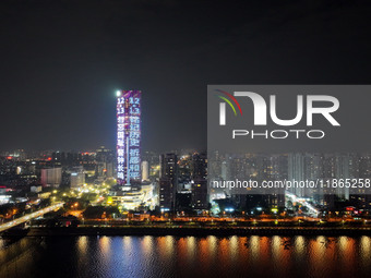 A large LED screen on the exterior wall of a building displays a propaganda slogan to commemorate the innocent victims of the Nanjing Massac...