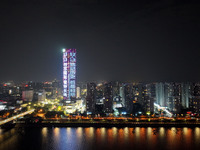 A large LED screen on the exterior wall of a building displays a propaganda slogan to commemorate the innocent victims of the Nanjing Massac...