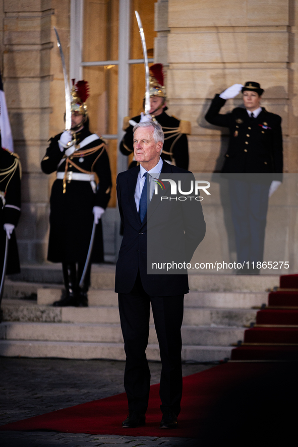 In Paris, France, on December 13, 2024, Michel Barnier, the resigning prime minister, awaits arrival at the Matignon entrance during the han...