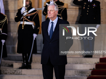 In Paris, France, on December 13, 2024, Michel Barnier, the resigning prime minister, awaits arrival at the Matignon entrance during the han...