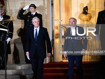 Michel Barnier, the resigning prime minister, and Francois Bayrou, the new French Prime Minister, are seen at the Matignon entrance during t...