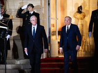 Michel Barnier, the resigning prime minister, and Francois Bayrou, the new French Prime Minister, are seen at the Matignon entrance during t...