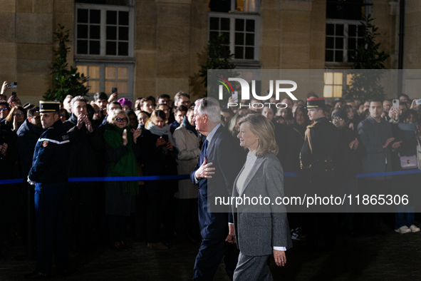 Michel Barnier, the resigning Prime Minister, departs at the end of the handover ceremony with his wife Isabelle Altmayer during the ceremon...