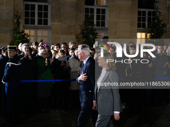 Michel Barnier, the resigning Prime Minister, departs at the end of the handover ceremony with his wife Isabelle Altmayer during the ceremon...