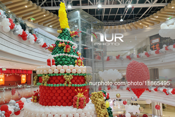 A 10-meter-high ''Christmas tree'' is decorated with colorful balloons and a ''heart'' in the atrium of a shopping mall in Xi'an, China, on...