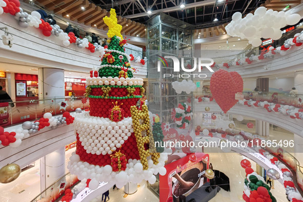 A 10-meter-high ''Christmas tree'' is decorated with colorful balloons and a ''heart'' in the atrium of a shopping mall in Xi'an, China, on...