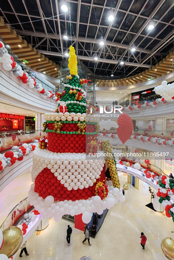 A 10-meter-high ''Christmas tree'' is decorated with colorful balloons and a ''heart'' in the atrium of a shopping mall in Xi'an, China, on...