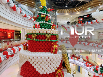 A 10-meter-high ''Christmas tree'' is decorated with colorful balloons and a ''heart'' in the atrium of a shopping mall in Xi'an, China, on...