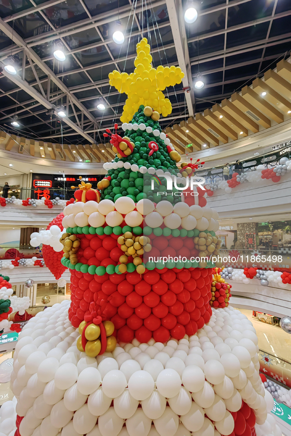 A 10-meter-high ''Christmas tree'' is decorated with colorful balloons and a ''heart'' in the atrium of a shopping mall in Xi'an, China, on...