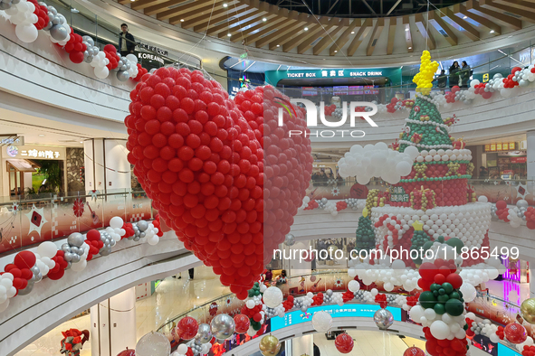 A 10-meter-high ''Christmas tree'' is decorated with colorful balloons and a ''heart'' in the atrium of a shopping mall in Xi'an, China, on...