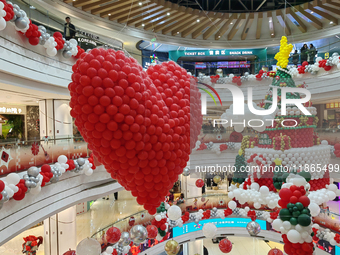 A 10-meter-high ''Christmas tree'' is decorated with colorful balloons and a ''heart'' in the atrium of a shopping mall in Xi'an, China, on...