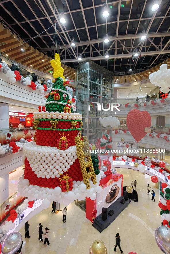 A 10-meter-high ''Christmas tree'' is decorated with colorful balloons and a ''heart'' in the atrium of a shopping mall in Xi'an, China, on...