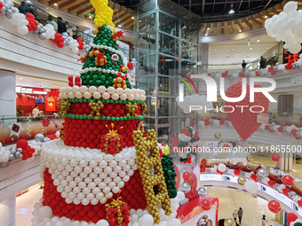 A 10-meter-high ''Christmas tree'' is decorated with colorful balloons and a ''heart'' in the atrium of a shopping mall in Xi'an, China, on...