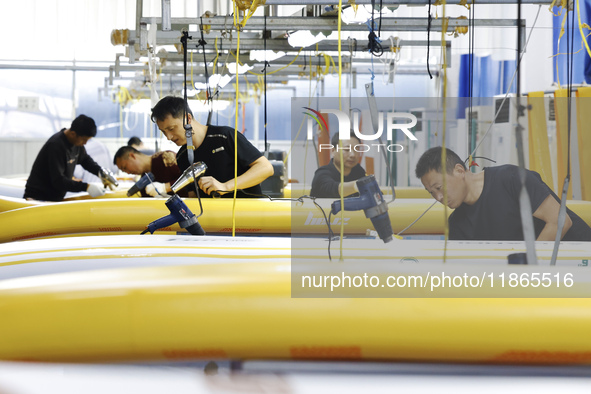 Workers produce surfboards for export to Europe and the United States at a production workshop in Suqian, Jiangsu province, China, on Decemb...