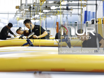 Workers produce surfboards for export to Europe and the United States at a production workshop in Suqian, Jiangsu province, China, on Decemb...