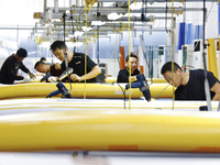 Workers produce surfboards for export to Europe and the United States at a production workshop in Suqian, Jiangsu province, China, on Decemb...