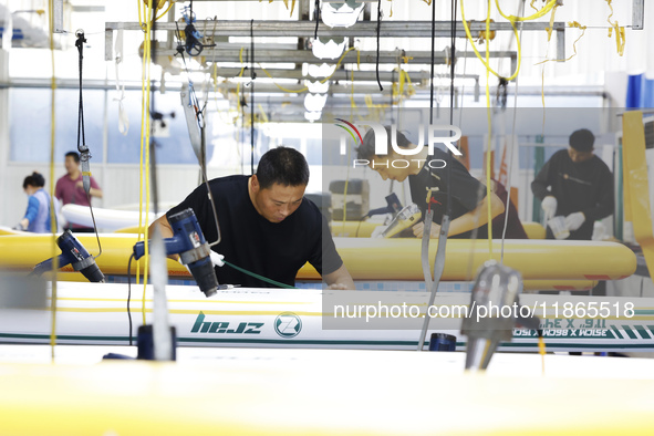 Workers produce surfboards for export to Europe and the United States at a production workshop in Suqian, Jiangsu province, China, on Decemb...