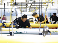 Workers produce surfboards for export to Europe and the United States at a production workshop in Suqian, Jiangsu province, China, on Decemb...