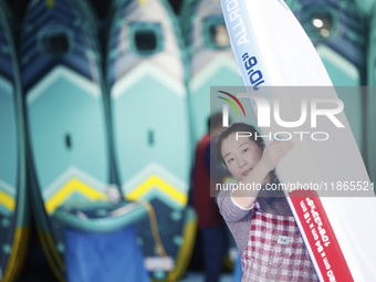 A worker produces surfboards for export to Europe and the United States at a production workshop in Suqian, Jiangsu province, China, on Dece...