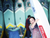 A worker produces surfboards for export to Europe and the United States at a production workshop in Suqian, Jiangsu province, China, on Dece...