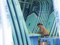 A worker produces surfboards for export to Europe and the United States at a production workshop in Suqian, Jiangsu province, China, on Dece...