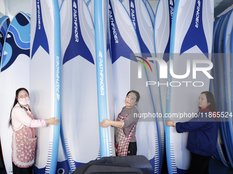 Workers produce surfboards for export to Europe and the United States at a production workshop in Suqian, Jiangsu province, China, on Decemb...