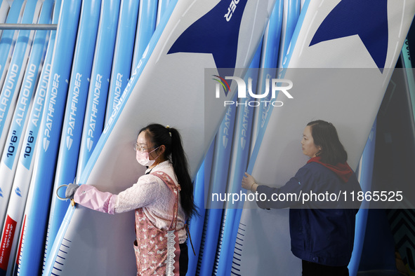 Workers produce surfboards for export to Europe and the United States at a production workshop in Suqian, Jiangsu province, China, on Decemb...