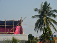 A worker works on a semi-finished tent set up on the rooftop of a building in Siliguri, India, on December 14, 2024. (