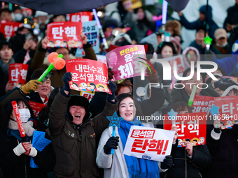 Citizens cheer after the impeachment of President Yoon Suk-yeol is passed in Seoul, South Korea, on December 14, 2024. Approximately 2 milli...