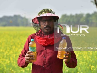 A beekeeper shows raw honey at a honeybee farm near a mustard field in Morigaon district, Assam, India, on December 9, 2024. (