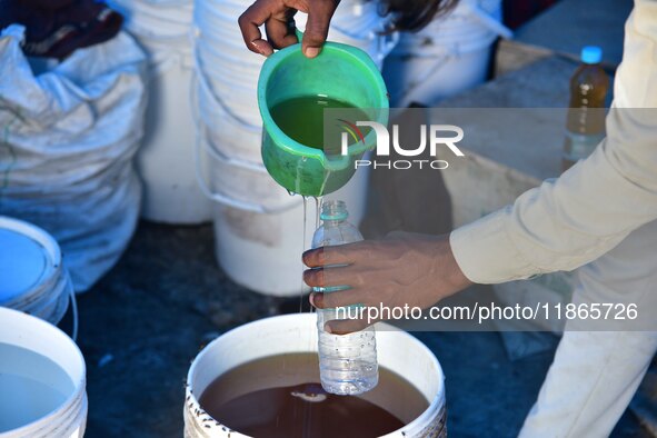 Raw honey is poured into a large storage can on the farm near a mustard field in Morigaon district, Assam, India, on December 9, 2024. 