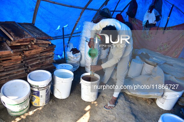 Raw honey is poured into a large storage can on the farm near a mustard field in Morigaon district, Assam, India, on December 9, 2024. 