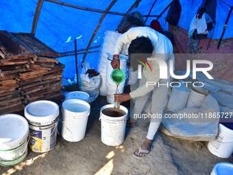 Raw honey is poured into a large storage can on the farm near a mustard field in Morigaon district, Assam, India, on December 9, 2024. (