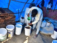 Raw honey is poured into a large storage can on the farm near a mustard field in Morigaon district, Assam, India, on December 9, 2024. (