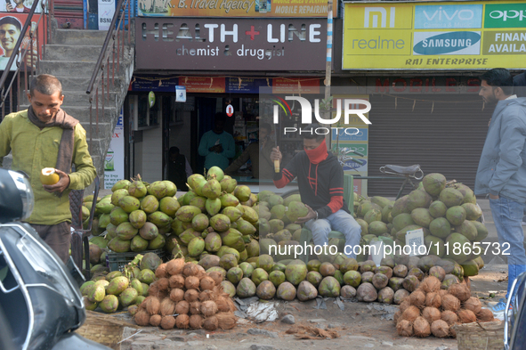 A roadside seller sells coconut water at his roadside stall in Siliguri, India, on December 14, 2024. 