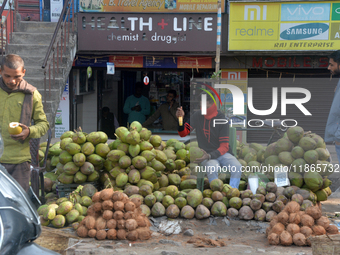 A roadside seller sells coconut water at his roadside stall in Siliguri, India, on December 14, 2024. (