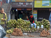 A roadside seller sells coconut water at his roadside stall in Siliguri, India, on December 14, 2024. (