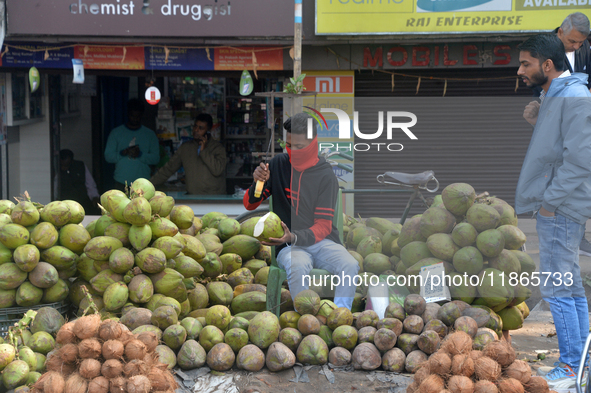 A roadside seller sells coconut water at his roadside stall in Siliguri, India, on December 14, 2024. 