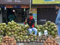 A roadside seller sells coconut water at his roadside stall in Siliguri, India, on December 14, 2024. (