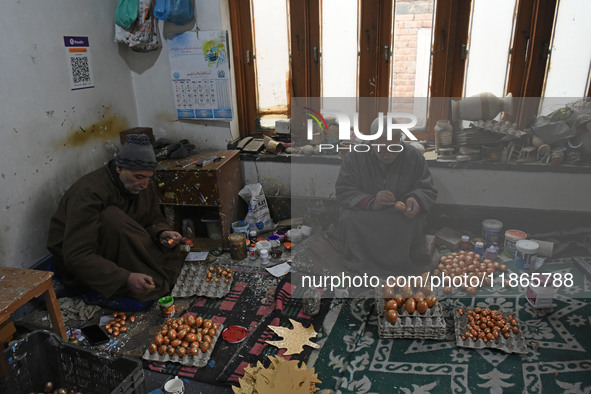 In Srinagar, Kashmir, India, on December 14, 2024, Kashmiri artisans paint Christmas ornaments at the workshop before sending them to the ma...