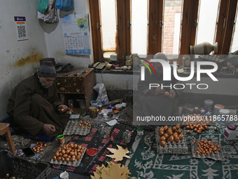 In Srinagar, Kashmir, India, on December 14, 2024, Kashmiri artisans paint Christmas ornaments at the workshop before sending them to the ma...