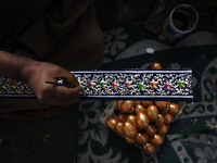 In Srinagar, Kashmir, India, on December 14, 2024, a Kashmiri artisan paints Christmas gift items at the workshop before sending them to the...