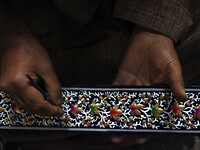 In Srinagar, Kashmir, India, on December 14, 2024, a Kashmiri artisan paints Christmas gift items at the workshop before sending them to the...