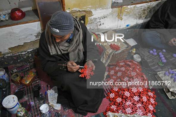 In Srinagar, Kashmir, India, on December 14, 2024, a Kashmiri artisan paints Christmas gift items at the workshop before sending them to the...