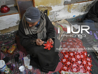 In Srinagar, Kashmir, India, on December 14, 2024, a Kashmiri artisan paints Christmas gift items at the workshop before sending them to the...