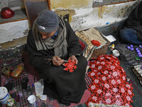 In Srinagar, Kashmir, India, on December 14, 2024, a Kashmiri artisan paints Christmas gift items at the workshop before sending them to the...