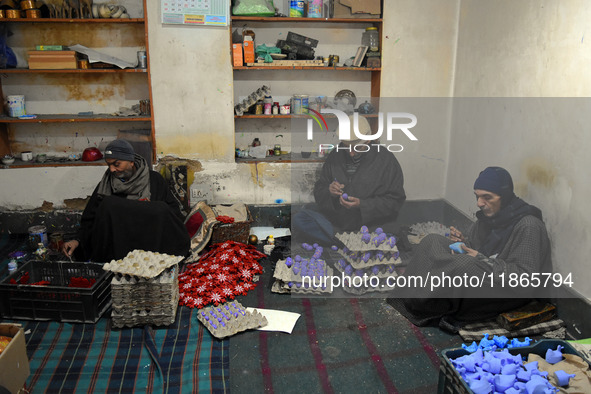 In Srinagar, Kashmir, India, on December 14, 2024, Kashmiri artisan Muhammad Akhtar Mir paints Christmas gift items at his workshop before s...