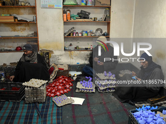 In Srinagar, Kashmir, India, on December 14, 2024, Kashmiri artisan Muhammad Akhtar Mir paints Christmas gift items at his workshop before s...