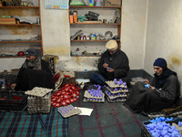 In Srinagar, Kashmir, India, on December 14, 2024, Kashmiri artisan Muhammad Akhtar Mir paints Christmas gift items at his workshop before s...