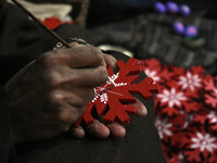 In Srinagar, Kashmir, India, on December 14, 2024, a Kashmiri artisan paints Christmas gift items at the workshop before sending them to the...